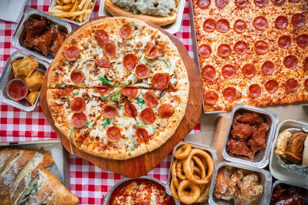 A top-down view of a pizza station, with some other dishes