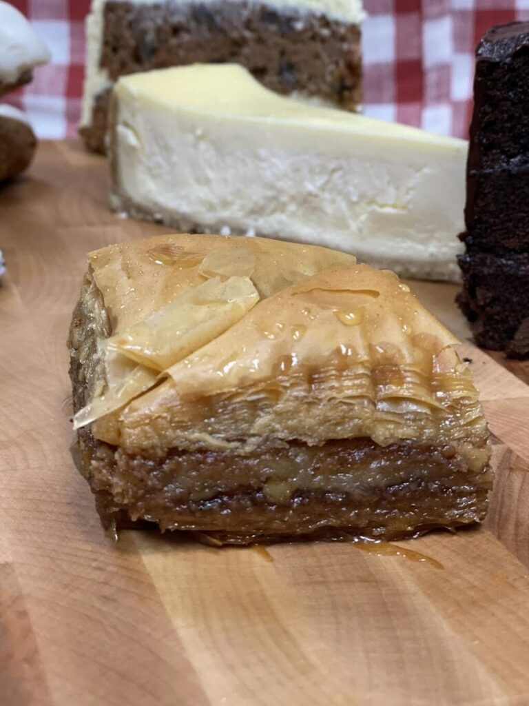 Delicious pieces of baklava arranged on a blue and white checkered paper, showcasing its flaky pastry and rich filling.