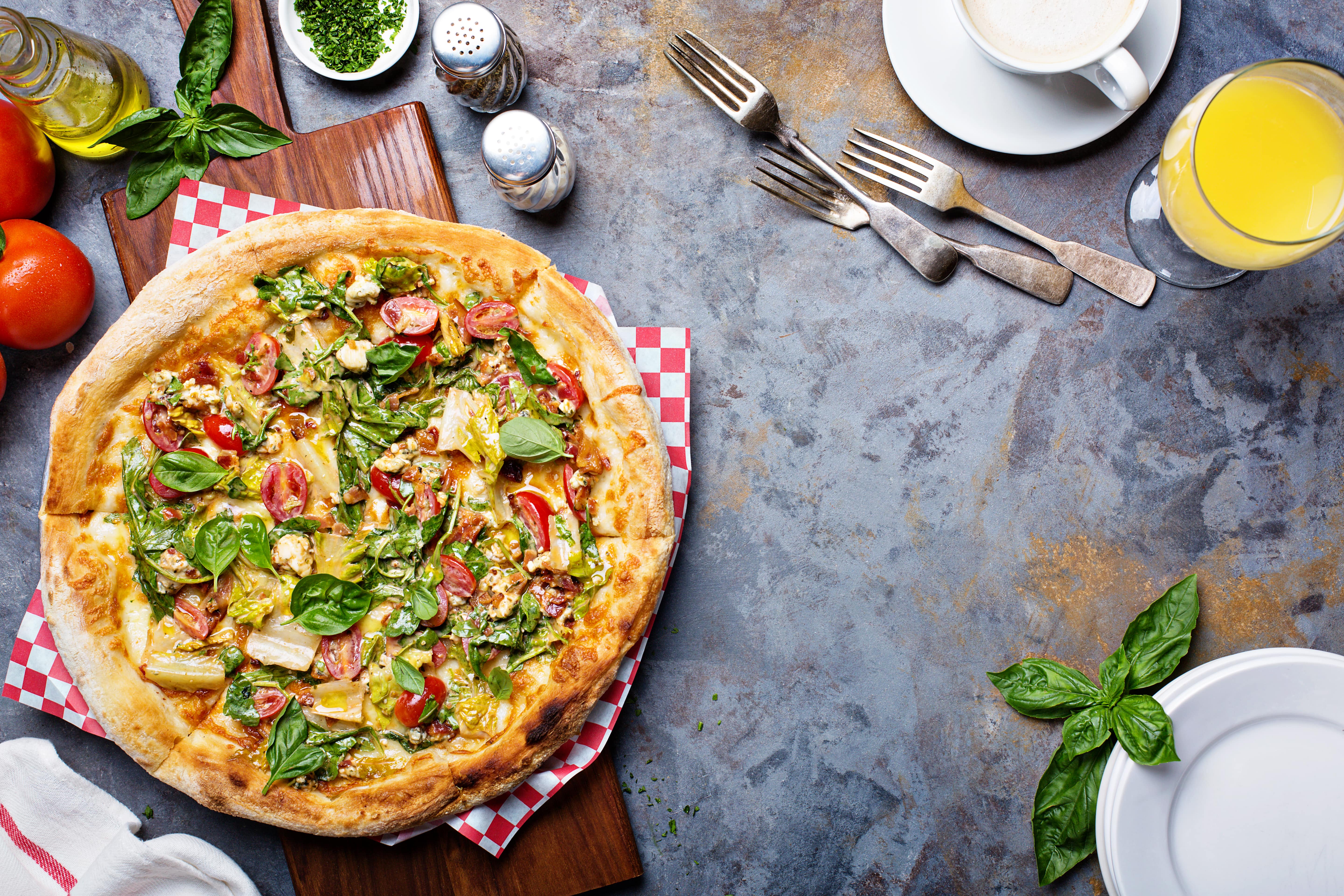 A delicious Caesar salad pizza with fresh tomatoes, crisp romaine lettuce, and creamy dressing.