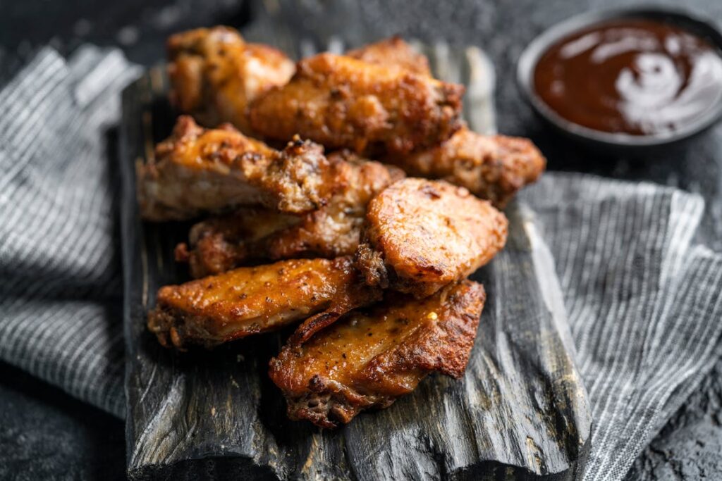  Close-up shot of buffalo wings served with ketchup.