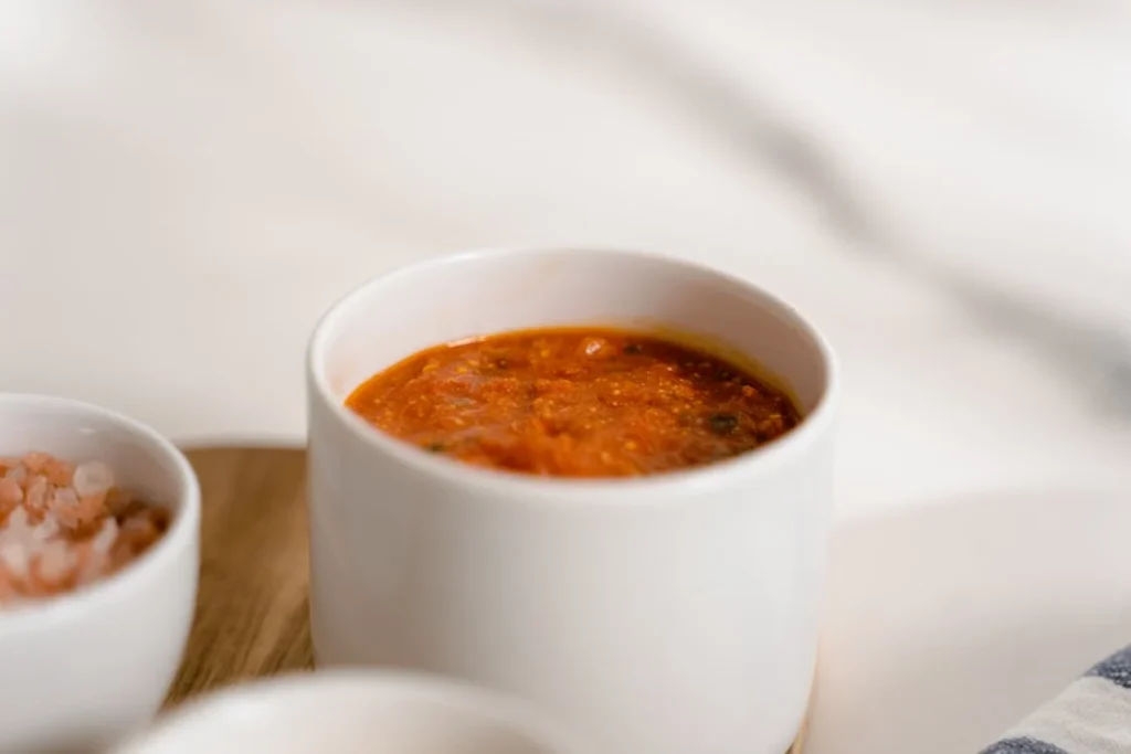 A close-up of marinara dipping sauce in a small bowl, perfect for pairing with traditional pizza or breadsticks.