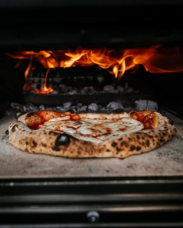 Close-up shot of a thick-crust pizza in a heated oven.