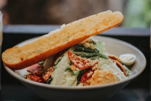 A sumptuous vegetable salad bowl with creamy garlic bread on the side.